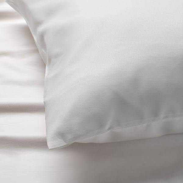 Close-up of soft white pillowcase, smooth texture, neatly folded.