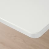 Closeup of clean, white, smooth table corner, showcasing quality finish.