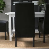 Black dining chair with wooden legs, cushioned for comfort and lumbar support. Removable, washable cover.