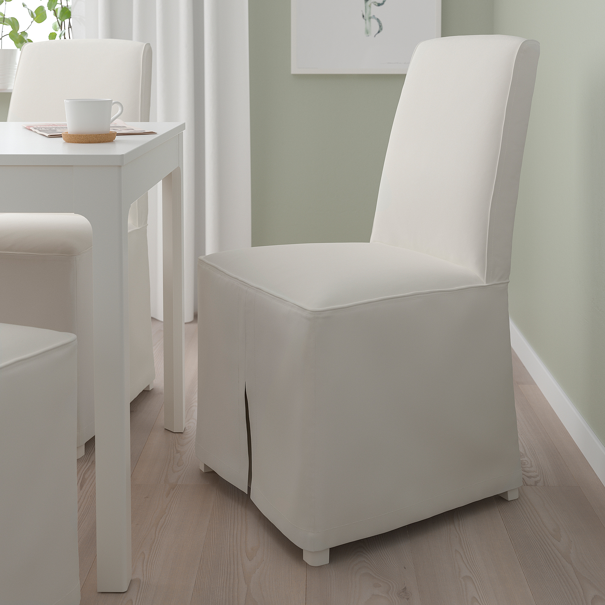 White BERGMUND chair with high back, next to table with mug and papers.