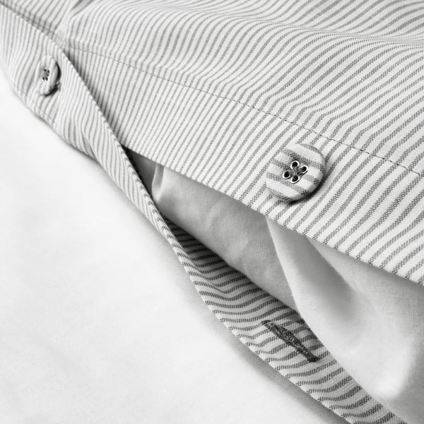 Close-up of striped duvet cover with single, decorative button. Shows fabrics texture and design detail.