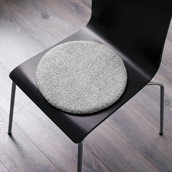 Black chair with small round grey seat cushion featuring dots on the back to keep it in place.