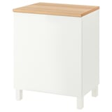 A white BESTÅ cabinet with a light oak top. It has clean lines and four white legs, offering both storage and a display surface.