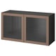 An ikea BESTÅ storage unit in dark brown with glass doors, showcasing a sleek and modern design.