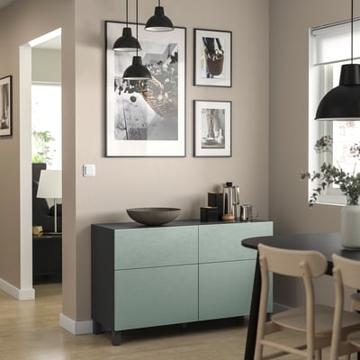 New dining room with light green BESTÅ sideboard, black accents, wooden chairs, hanging lights, and wall photos.