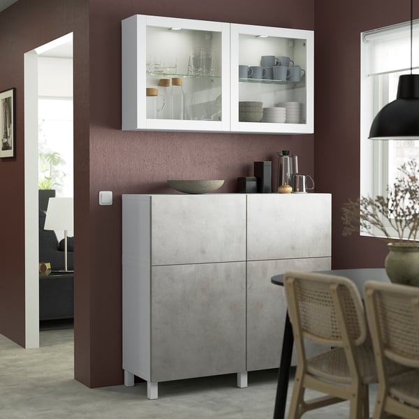 Modern BESTÅ storage unit with glass display, grey, near dining table.