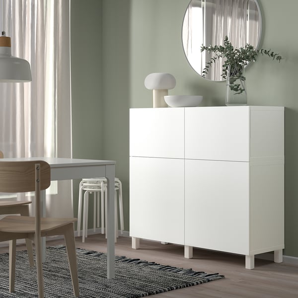 Modern living room with BESTÅ cabinet, mirror, and wooden table.