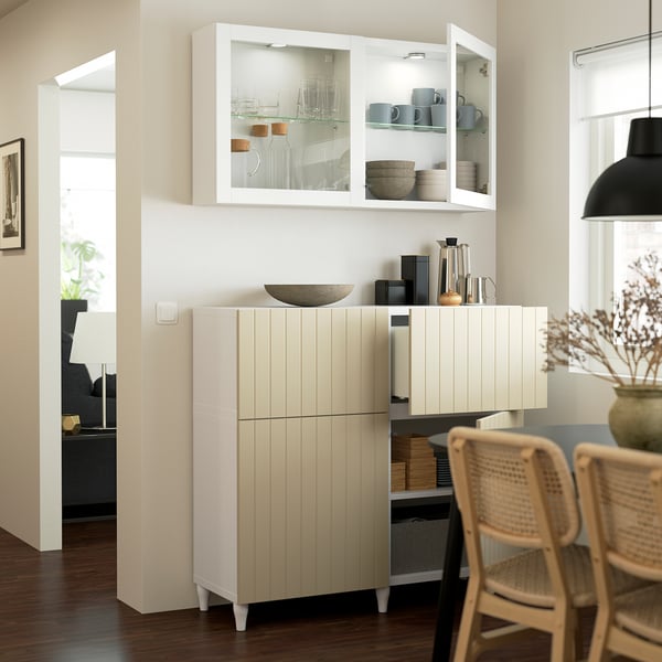 A modern kitchen with glass and wood cabinet displaying cups and bowls, providing both storage and decor.