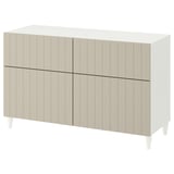White BESTÅ sideboard with vertical panels, rectangular shape, four doors, and slightly tapered legs.