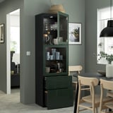 Modern glass-door cabinet displays dishes and mugs. Household items are stored in both open and enclosed sections.