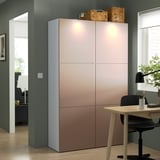 Large BESTÅ storage unit with pinkish-brown doors, black chair, and desk in minimalist room.