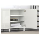 White BESTÅ storage unit with adjustable shelves and soft-closing doors. Books and trays stored inside.