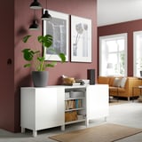 White BESTÅ sideboard displays books, plant, and bowl; offers storage and aesthetics in a red living room.