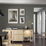 Modern dining room with glass-front sideboard, photos, and branch decor.