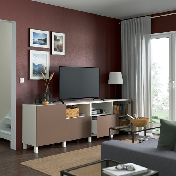 Modern living room with maroon walls, featuring a BESTÅ tv bench with adjustable shelves, flat-screen tv, and organized storage.