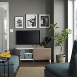 Modern living room with BESTÅ tv bench, flat-screen tv, soft-closing door, lamp, and plant.