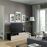 Modern living room with BESTÅ tv unit, flat-screen tv, lamp, and glass coffee table.