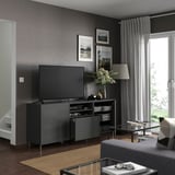 Modern living room with BESTÅ dark grey tv bench, flat screen, decor, and large window.