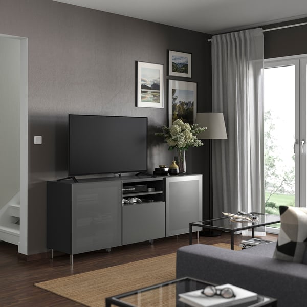 Modern living room a BESTÅ tv bench in dark grey with storage, a flat-screen tv, and a glass coffee table.