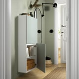 Modern open cabinet displays books and baskets, with sleek wall-mounted lamp above.