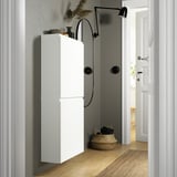 Modern hallway with BESTÅ wall cabinet in white, taller than door basket, next to wall lamp.