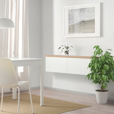 Minimalist white desk with chair, plant, and artwork, ideal for modern spaces.