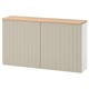 A beige ikea BESTÅ storage unit with oak top and push-open doors.