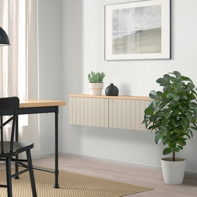 Modern living room with BESTÅ storage, plants, chair, desk, nature print.