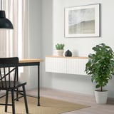 Modern decor with large plant, framed art, and BESTÅ storage unit beneath a window. ”