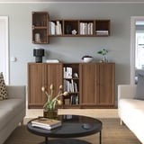 Modern living room with BILLY bookcases in wood finish, featuring seating, a coffee table, and decor.