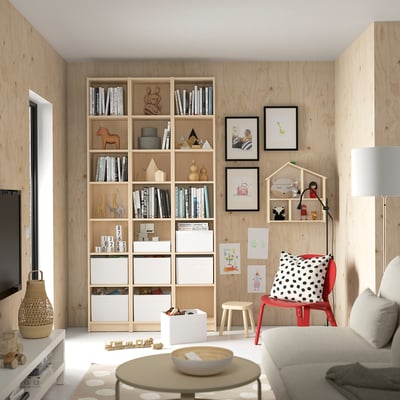 Cozy living room with BILLY bookcase, red chair, and toys.