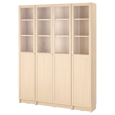 A BILLY bookshelf in white stained ash. It has four sections, with upper glass doors and lower solid doors. The shelves are adjustable.