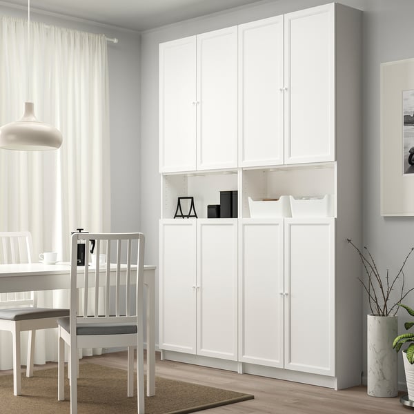 White BILLY bookcase with inset doors, tall, minimalist, in dining area with chair.