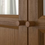 Close-up of wooden cabinet hinge, showing detailed craftsmanship and quality.