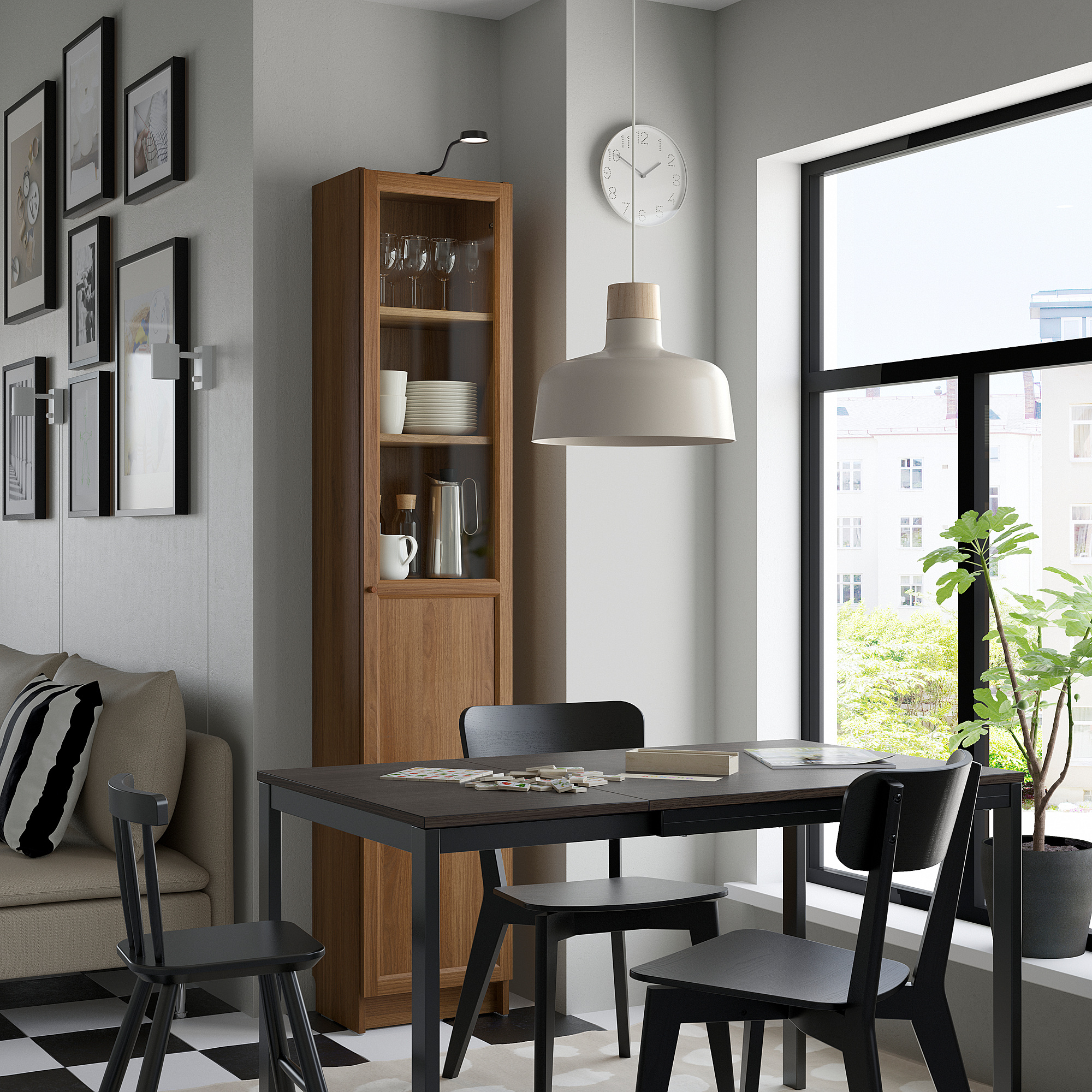 Cozy dining space with BILLY bookcase, black chairs, table, and decor.