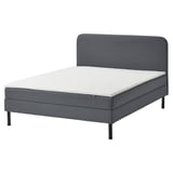 Gray divan bed with white mattress, padded headboard, modern design.