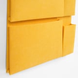Bright yellow fabric hanging organizer with multiple pockets, sturdy construction, and large hanging holes.