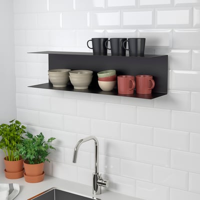Wall-mounted BOTKYRKA shelf, black, metal, rectangular; holds cups and bowls, sized larger than mugs.