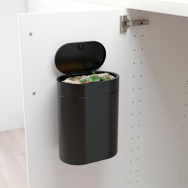 Black bin in white cabinet, open for organics, narrow-space friendly with press lid and bag handles.