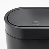 Modern black cylindrical trash bin with sleek, touch-open lid, showcasing high-quality materials and design.