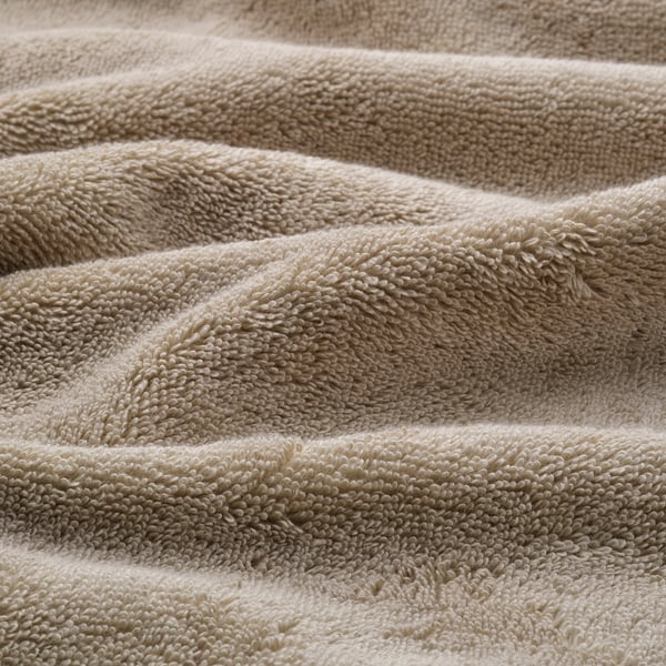 Folded organic cotton towels, soft, thick, woven border detail.
