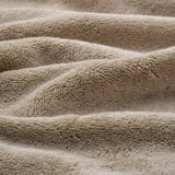 Folded organic cotton towels, soft, thick, woven border detail.
