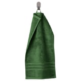 Green BROKGLIM towel hangs neatly on a hook, featuring a woven border and soft, absorbent organic cotton.