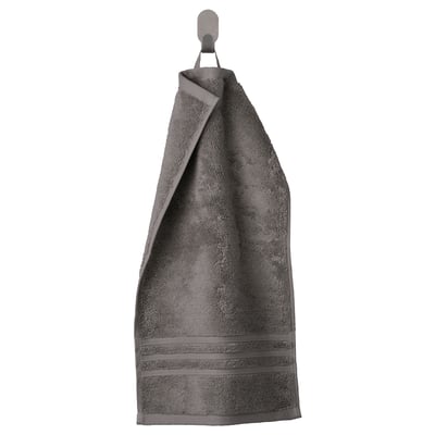 BROKGLIM grey organic cotton towel with woven border hangs neatly on hook.