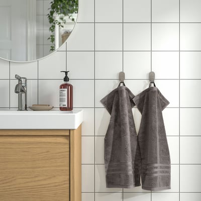 Gray towels on hooks in modern bathroom. Gots-certified, thick, absorbent, decorative border, oversized.