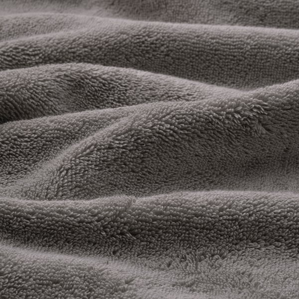 Close-up of soft, folded gray towels with intricate designs, showcasing premium texture and quality.