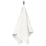 BROKGLIM white towel hangs neatly on a hook, showcasing its soft, absorbent fabric with a decorative, woven border.