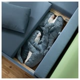 Blue l-shaped sofa-bed with stuffed sharks; modern, cozy, storage.