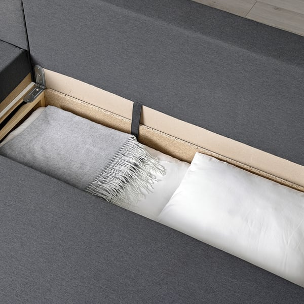 Sofa-bed with cushions, featuring built-in storage and a convertible design.