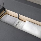 Sofa-bed with cushions, featuring built-in storage and a convertible design.